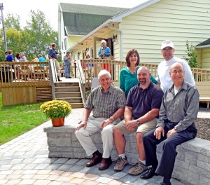 Primary contributors to the design and construction of the Memorial Garden at Christ Community Church are (standing) church members Beth and Doni LaRock, (seated, l to r) church members Jerry Klafehn, Jerry Opalecky, and Pastor Bruce Plummer.  In the background a lunch was held on the new deck after the garden dedication on September 15.  Photo Dianne Hickerson.