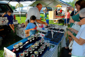 Peter Childs of the Tan Childs Farm from Hinsdale, more than eighty-five miles from North Chili, sells jam and fresh blueberries with his two children, Christy and Robert, at the North Chili Farmers Market. Peter says that the children’s official job is blueberry eaters.