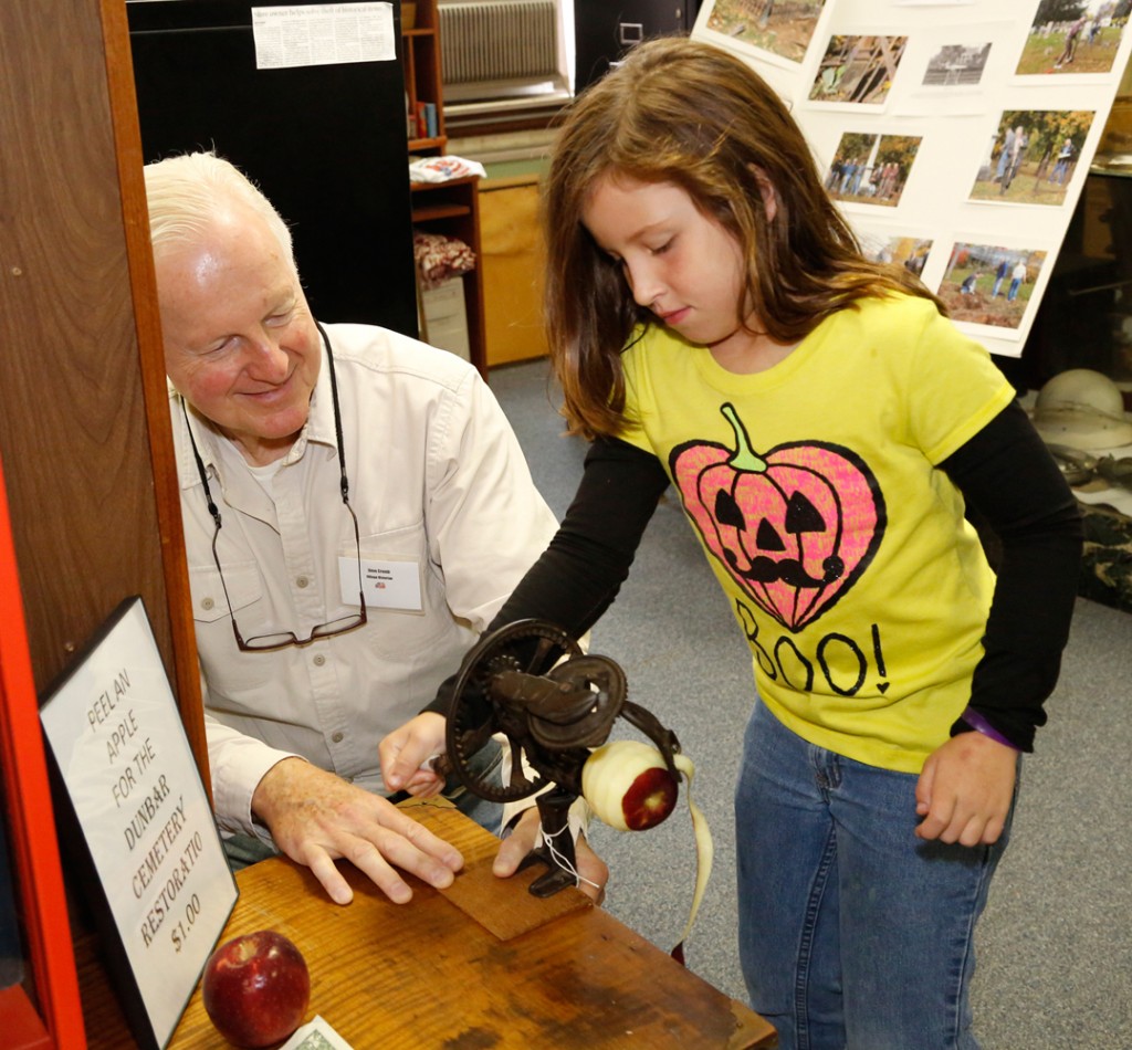 Hilton historian Dave Crumb helps Hilton’s Hayley Wolf, 8, peel an apple using an aged apple peeler from the Hilton museum. The corer was manufactured in 1890 and the German steel cutting blade is still going strong.