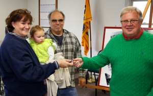 Supervisor Dick Moy hands the keys to the old Stone Store to Sue Fertitta as Joe and granddaughter Jazlyn watch.