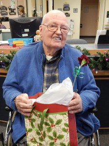 Beikirch resident Olof Carlson gives a smile before opening his Christmas gift.  He was one of  the 114 residents who each received a gift from the Brockport Auxiliary Service Corporation (BASC).