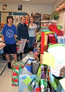 Hilton seventh graders (l-r) Bradley Carr, Brooke Pearce, Margarite Korolchuk and Michael Bilby with the hundreds of gifts donated to the Society for the Protection and Care of Children by Merton Williams Middle School students and staff.