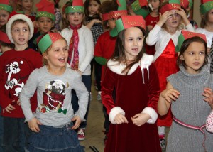 Byron-Bergen Elementary School kindergarten students encourage the audience to sing along as they belt out Christmas carols at the Gillam-Grant Community Center. 