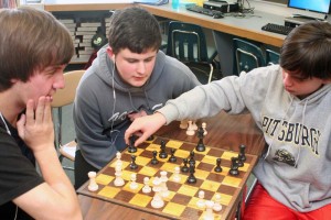 Eighth-graders Max Leisenring (left) and Joshua Fry (right) compete in the early rounds of the chess tournament as Tyler Lincoln observes.