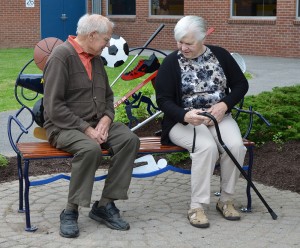The grandparents of the late Rob Stultz, Al and Esther Fiege of Ogden, have some quiet time to study the newly re-installed bench at Spencerport High School.
