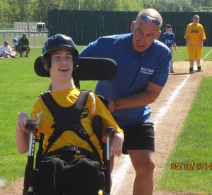 Volunteer Joe Setek helps Josh Lapp around the bases.