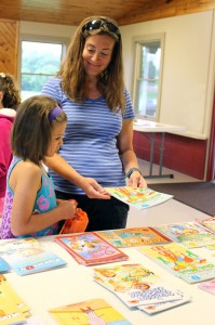 Tania Beghini helps her daughter, Sofia, a Quest Elementary School student, choose books during the Breakfast and Books event to help promote reading during school breaks. 