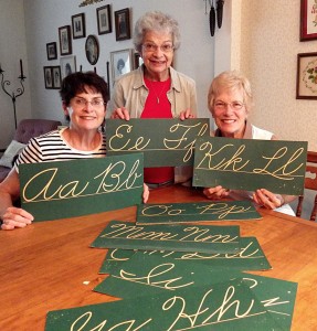 Monica Anderson, Chris Mazzarella, and Ruth Rath will teach cursive writing and other classes to children attending the Summer School Camp at Clarkson Academy.  Here they are planning the cursive classes at Mazzarella’s home.
