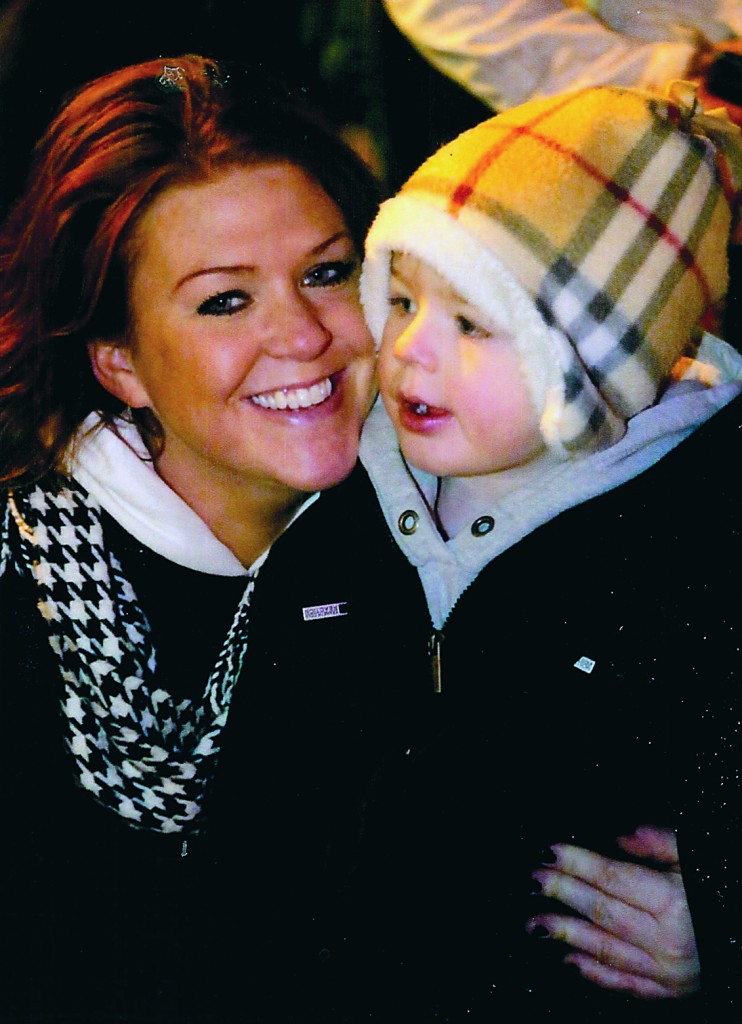 Three-year-old Braden Dady and his Mom, Claire, from Hamlin, watch as the lighted parade floats and trucks roll by. 