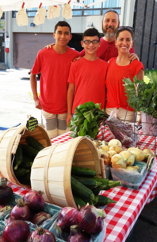 The Mortellaro family worked in the Red Wagon Farms tent at the Brockport Farmers Market on July 19, a business started by 14-year-old Mateo. Shown left to right: Mateo, brother Tiago, mother Stephanie and father Matt. Photo by Dianne Hickerson