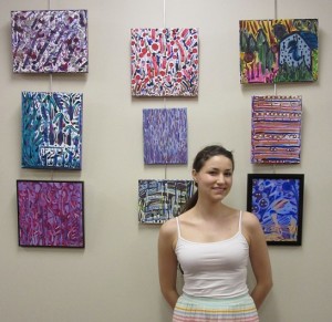 Elise Kull stands in front of her artwork currently on display at the Parma Public Library. Provided photo