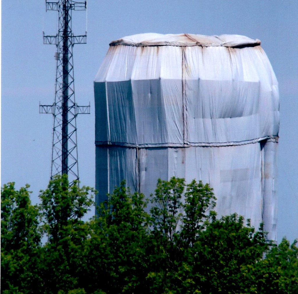 June 4, 2016 - The shroud of Hilton. The water tower is encased with fabric over a skeleton of scaffolding. The shroud contained the debris resulting from sandblasting the surface to remove the old paint. The interior was also sandblasted and required three different coatings on its surface.