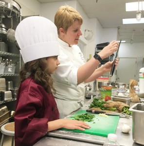  AnnaSerra Weider listens carefully to professional chef Ashleay as she gives instructions on preparing a meal. Provided photo