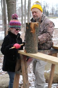 Nature conservationist and Spencerport volunteer, Norm Wolfe, demonstrates the process of tapping for maple syrup with a visitor last year. 