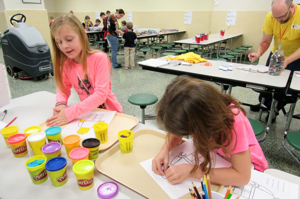 Addison Kludt, age seven (left) and Adriana Schiavone, age seven, work with play dough to create LEGO figurines during the second annual LEGO Workshop at Kendall Elementary School. The workshop is hosted during February break by Kendall Recreation.