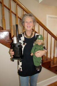 Teresa Wood of Churchville poses with one of her WWI era Salvation Army/Donut Girl dolls and a pot-bellied stove she created for one of her new History House programs. K. Gabalski photo.