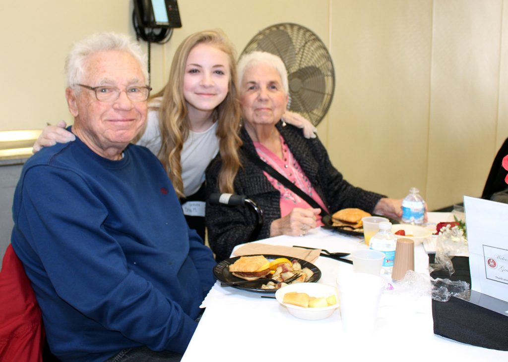 Bria Melrose, an eighth grader at Merton Williams Middle School in Hilton, serves breakfast to her grandparents, Bob and Sue Melrose, during the annual Grandfriends Breakfast. Provided photo