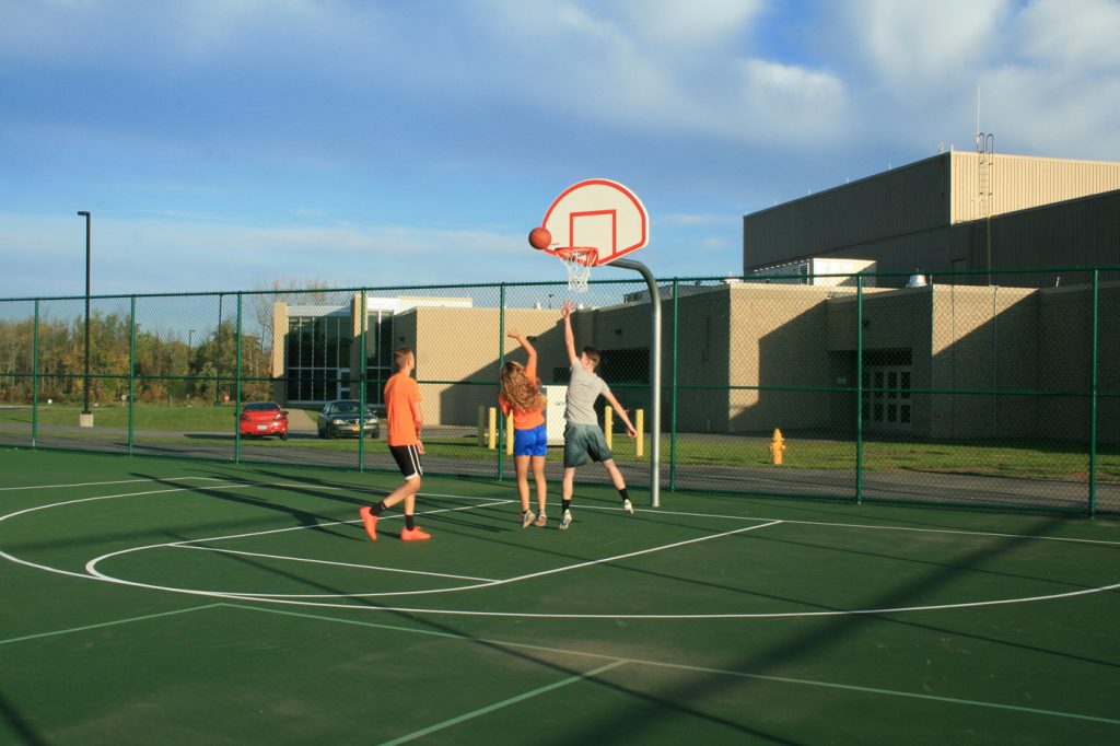 Students play a quick game of pick-up basketball on the new court. Provided photo