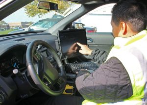 Security Officer Allain demonstrates the touchscreen and onboard capabilities of the new mobile digital computer. Provided photo