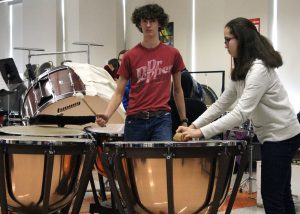 Band members Joshua Brink and Audrey Kohlman work on perfecting “rolling the ‘Do’” using timpani and a rolling pin, with direction from the composer himself. Provided photo