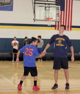 Hunter Streb gives Coach Noah a high five as he is introduced before the game. Photo by M. Fitzgibbon