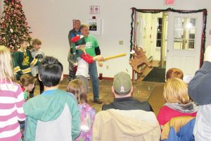  Paul Kimball assists a participant with the holiday pinata game. K. Gabalski photo