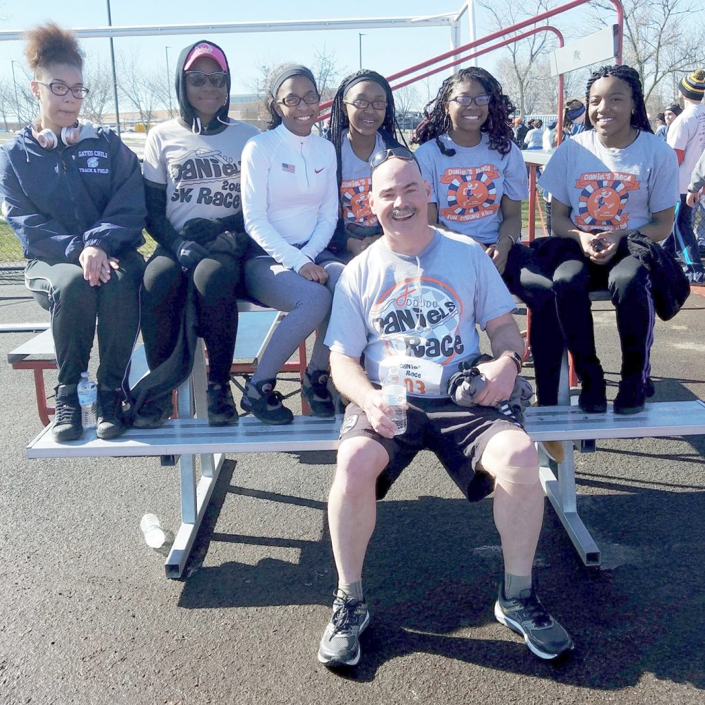 Daniel’s father Dean Myslivecek is shown with a group of track athletes from Gates Chili at the 2017 race. They are wearing different Daniel’s Race t-shirts to show their years of support. Myslivecek, who is a teacher and track coach at Gates Chili said, “Historically Gates Chili and Churchville-Chili sports teams have been very supportive of Daniel’s Race and the good work we are doing. Cancer touches all of our lives. We can make a difference and when we do it collectively, and celebrate the lives of those affected, it makes the good work we do fun.”