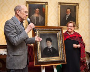A portrait of Susan Morgan was unveiled by Alicia Fink at the Morgan-Manning House on March 18. The event was the 150th birthday celebration for Sara Manning, Susan Morgan’s daughter.  Gordy Fox, vice president of the Western Monroe Historical Society, presided. In the background are portraits of Phebe and Hiel Brockway, founders of the Village of Brockport. Photography by Gregory Lawrence. Used with permission. 