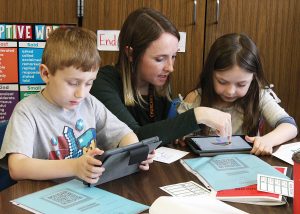 Instructional Technology Specialist Megan Hugg works with a team of Churchville Elementary School students using online resources to understand math problems. Provided photo 