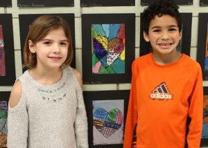 Fairbanks Road School first-graders Tessa Klim and Max Burnley are proud of their abstract heart designs, created with the guidance of art teacher Gretchen Foehner. 