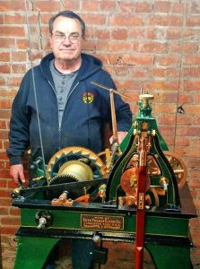Charles “Chuck” Roeser stands with the clockworks which were restored by his company, the Essence of Time Tower and Street Clock Experts in Lockport. As hands-on owner of the company, he spent the day disassembling and assembling the unit that was carried up to the tower in parts. The clockworks were restored to the original condition including the pin stripe paint detail. Cables can be seen which are connected to weights that power the clock and bell strike. Provided photo