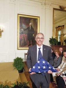 Albrecht promised his class he would take a photo in front of Washington’s portrait with their class flag. Provided photo
