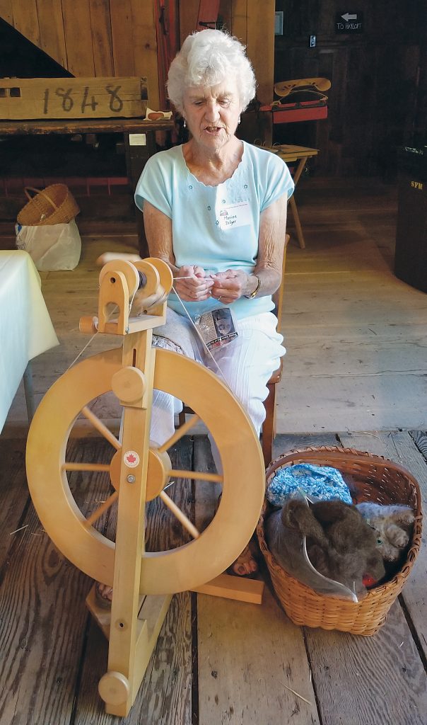 Marion Dilger used her antique spinning wheel to demonstrate how fibers are spun into yarn.