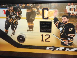 Shadowbox created with mementos from Brian Gionta’s 1,000th NHL Game including his hockey puck and stick and several photos from the game held on March 27, 2017. Photo by Karen Fien