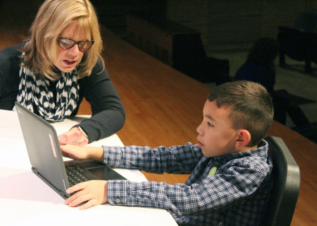 Board President Dr. Cheryl Repass learns about myOn from one of the student experts from CRS. Provided photo