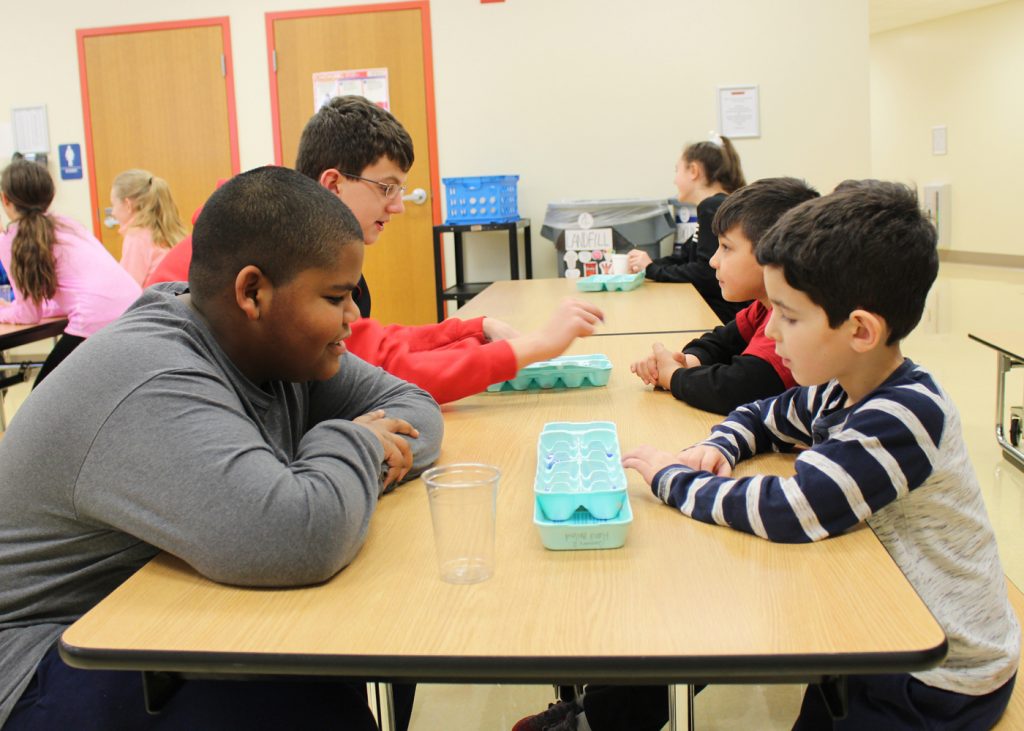 Issak Beaty (left), a sixth grader at Northwood Elementary School, and Dylan Frisicano, a first grader, play Mancala during “Drop Everything and Play.” 