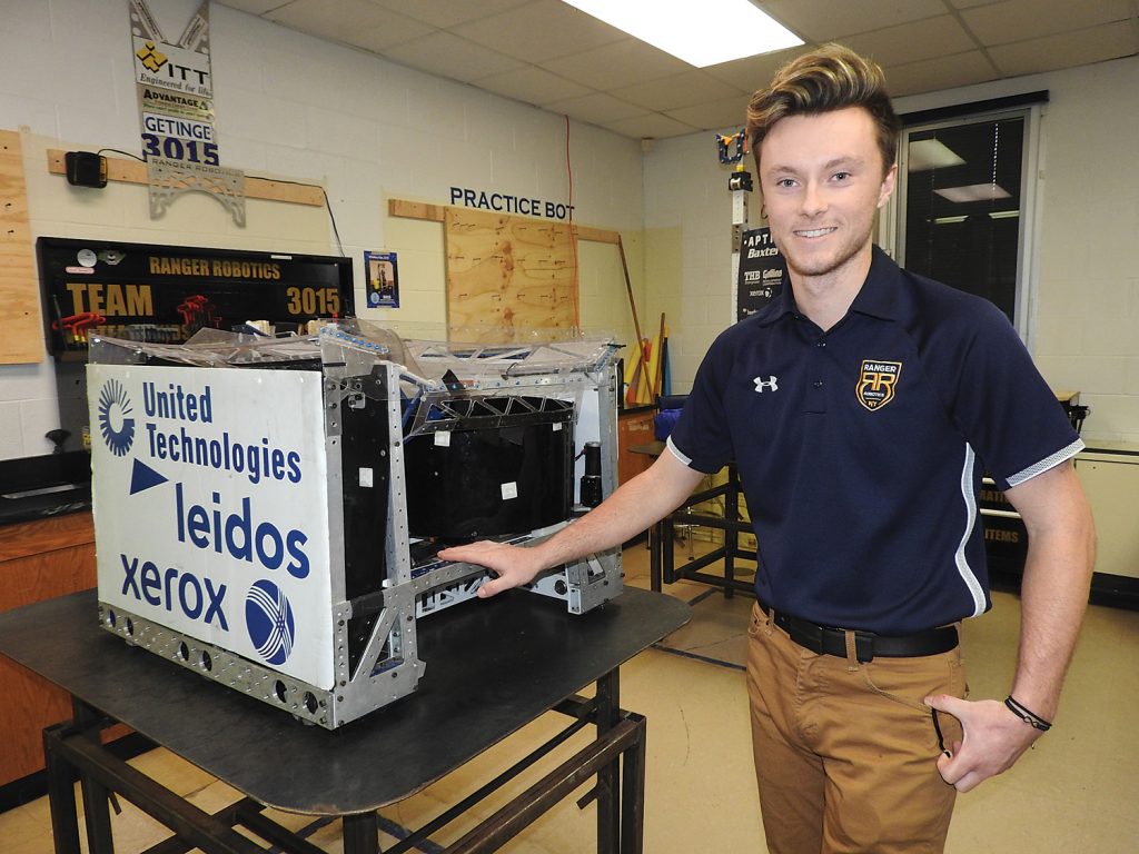 Sean Bracken with the robot from the 2017 competition season. It’s name is QuickDraw. During competition, it would shoot balls, pick up gears, and climb a rope. Now, as a demonstration bot, it only shoots balls.