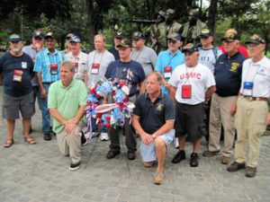 Assemblyman Steve Hawley, right of wreath, poses for a photo with Assemblyman Michael DenDekker, left of wreath, and veterans in front of the Vietnam War Memorial during last year’s Patriot Trip to Washington D.C. 