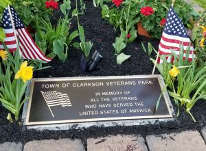 On May 23, a plaque honoring veterans was dedicated in the Town of Clarkson’s Veterans Park, on Ridge Road. The park setting with a stone garden, three benches, and a flag waving overhead was developed over 10 years. 