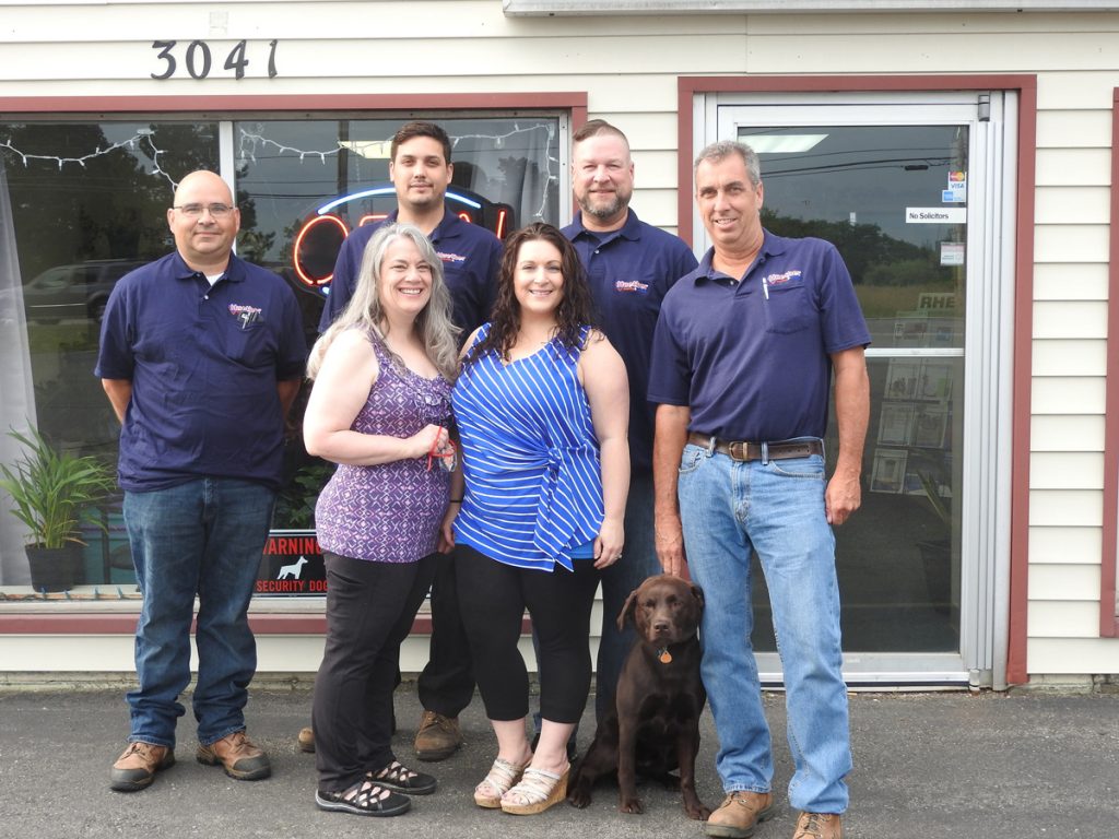 Huether Heating & Cooling is celebrating 50 years in business. Back row (l-r): Bob Michalowski, Dave Veator, Brian O’Connor and John Huether Jr. Front row (l-r): Barbara Clark, Holly Sibbald and furry family member Delilah Huether.