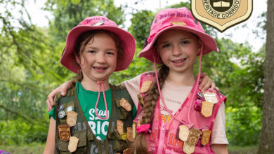 Two Junior Rangers display their Junior Ranger badge collections at Kenilworth Aquatic Gardens during the 2025 Lotus and Water Lily Festival.